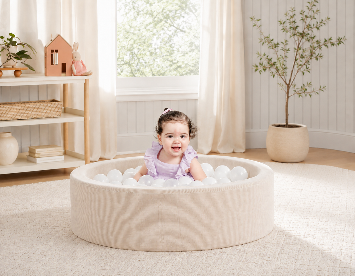 Niña jugando dentro de una alberca de pelotas CUBINO color ivory en su cuarto de juegos